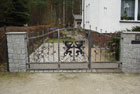 schmiedeeisernes Tor mit Zierrosen und Wappen
